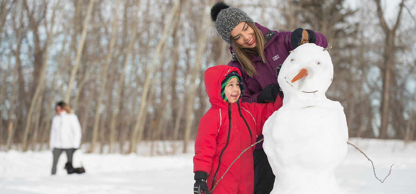 Woman and child building a snowman
